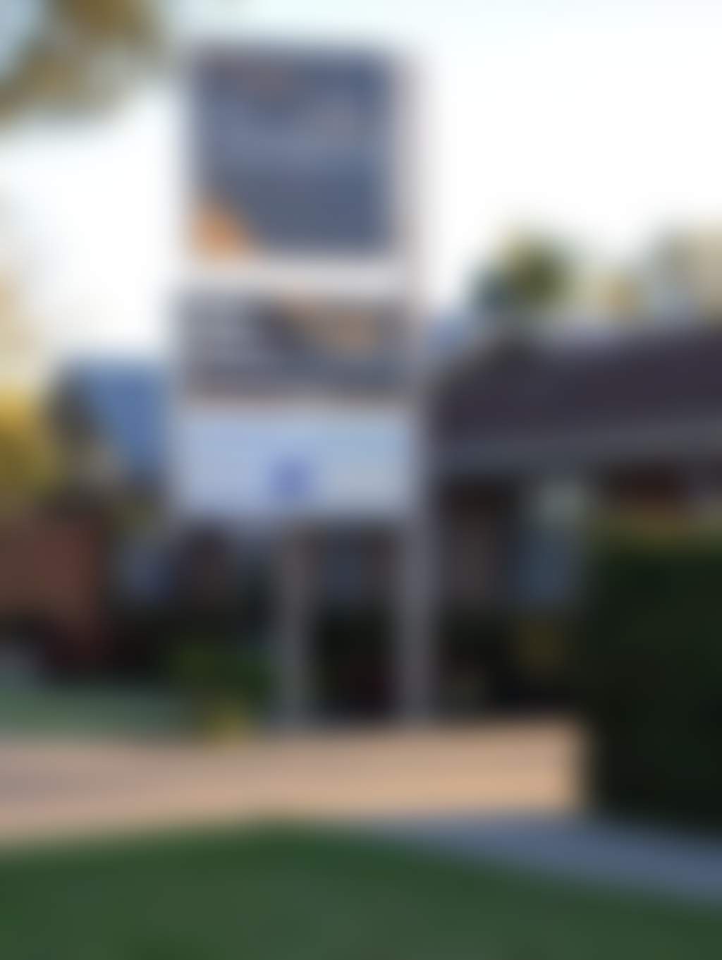 Exterior of motel in a tree-lined street