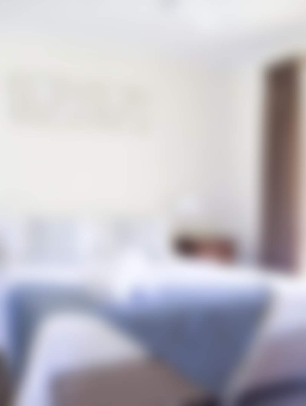 Neatly decorated queen bedroom with large floor to ceiling window