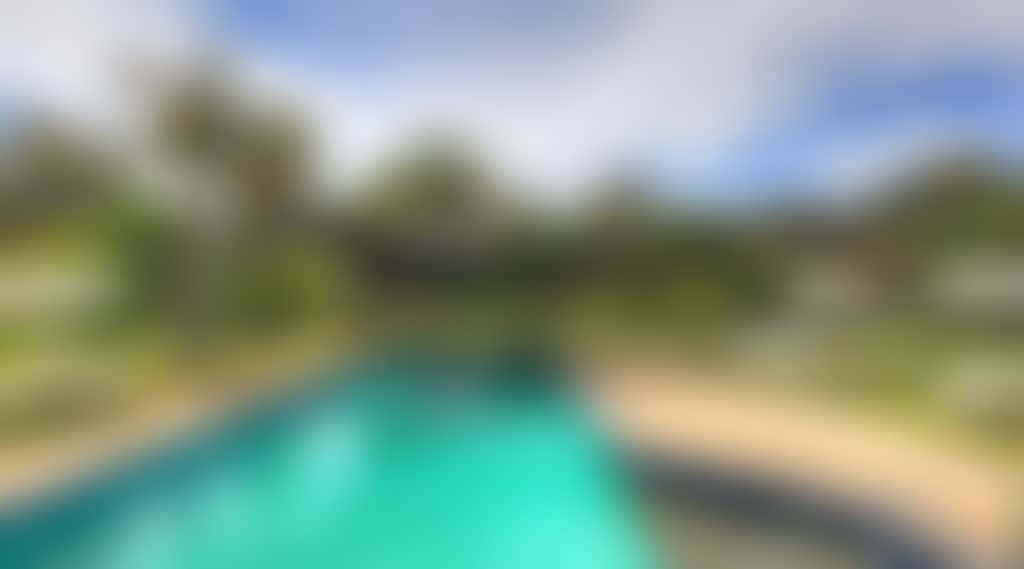 Blue pool amongst the green trees of the caravan park