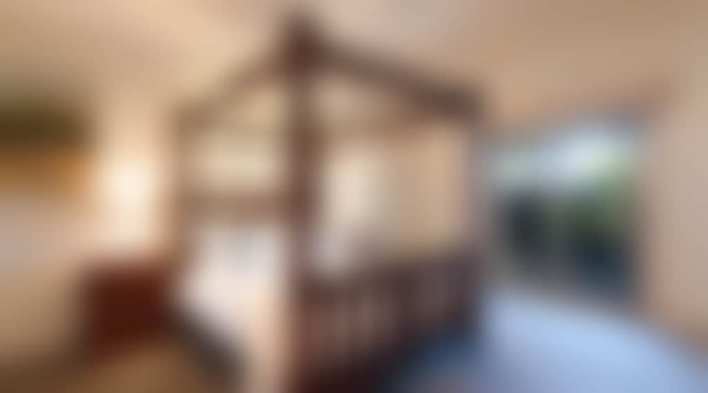 Grand four-poster bedroom with decorative paintings and fan