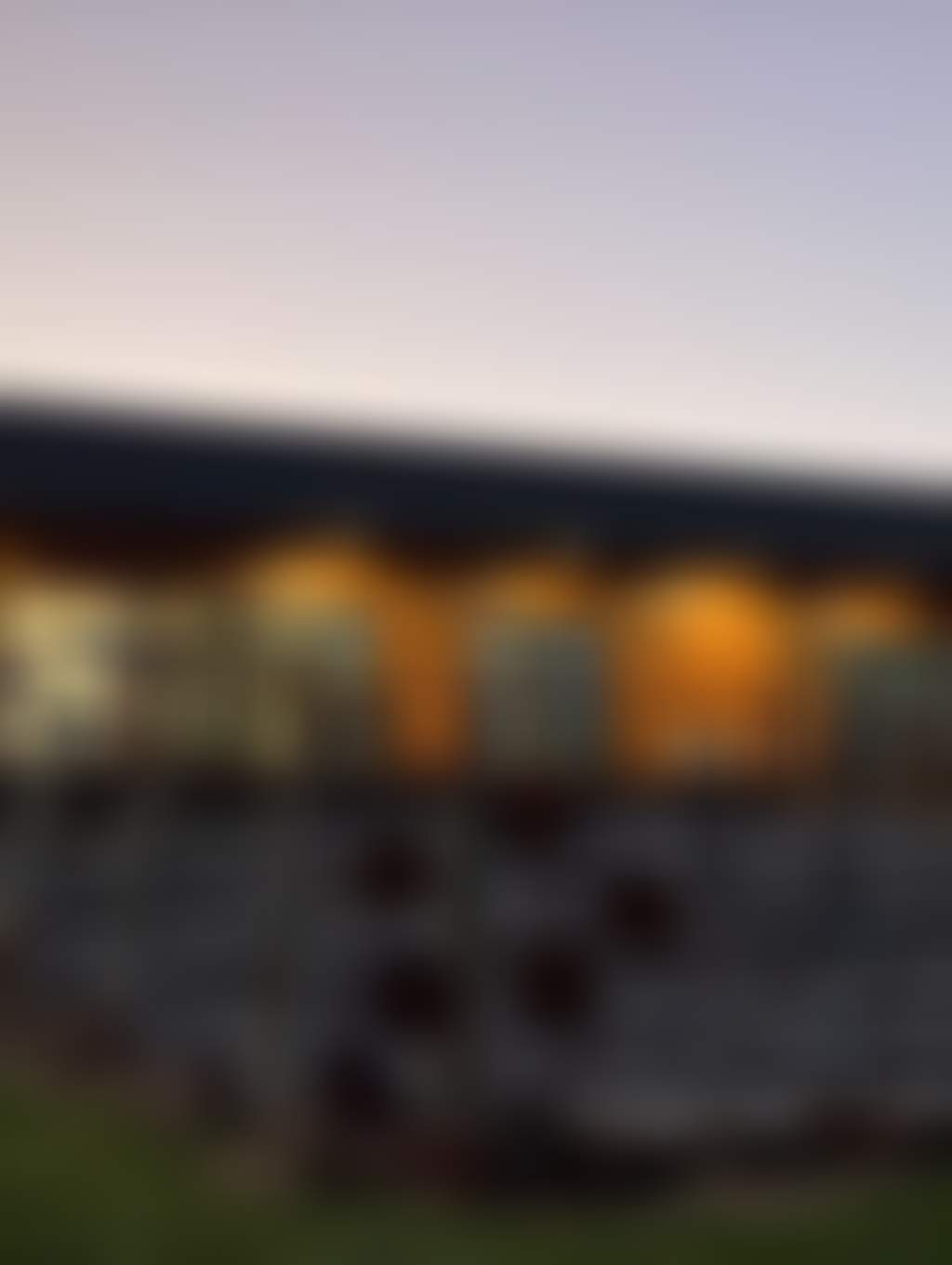 Cellar door building pictured at dusk vines in the foreground and