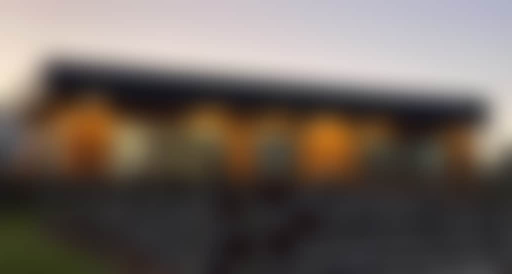 Cellar door building pictured at dusk vines in the foreground and