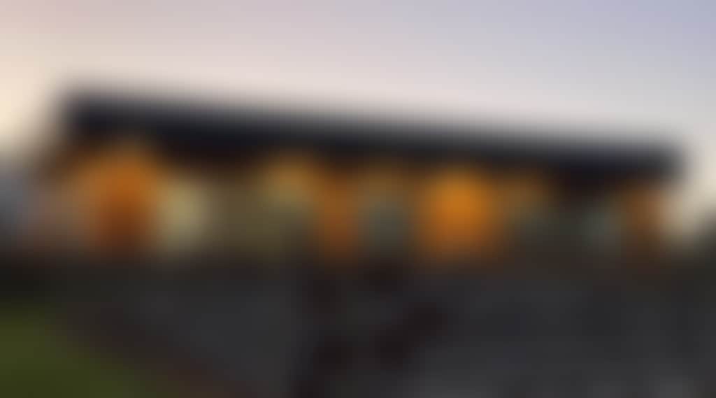 Cellar door building pictured at dusk vines in the foreground and