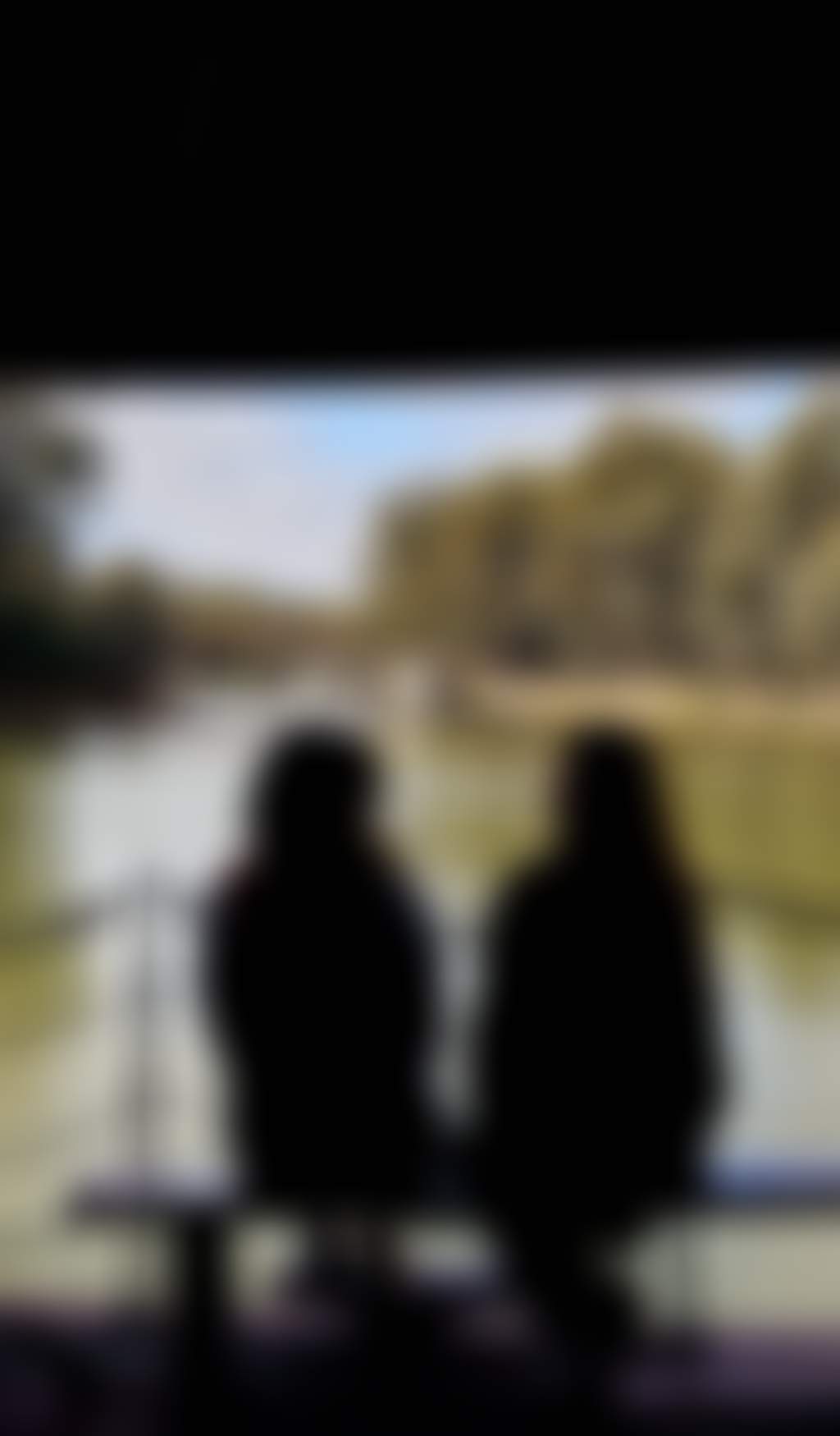 Two people sitting looking out over the Murray River Echuca