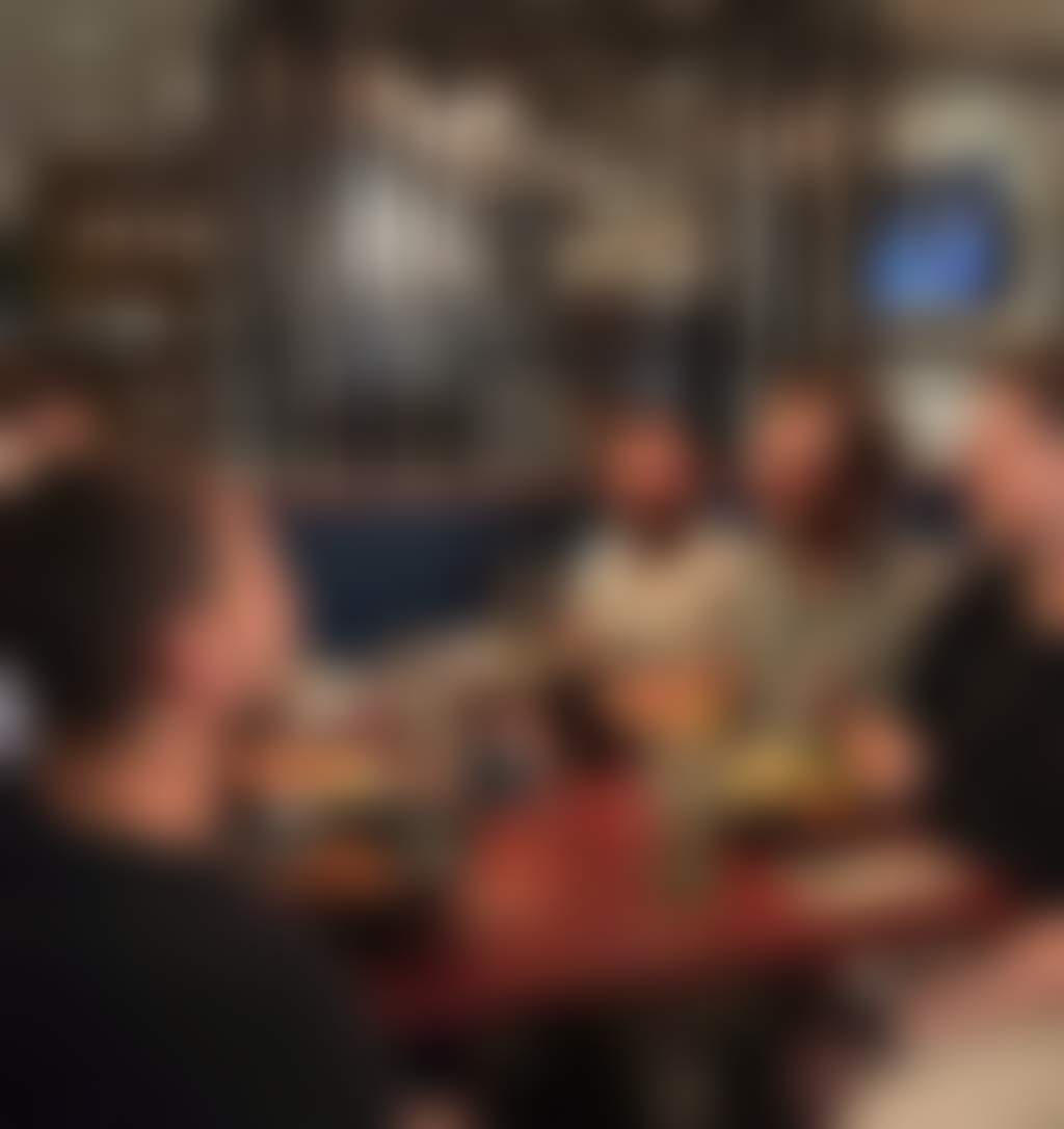 A group of friends enjoying food and drinks in a bistro setting