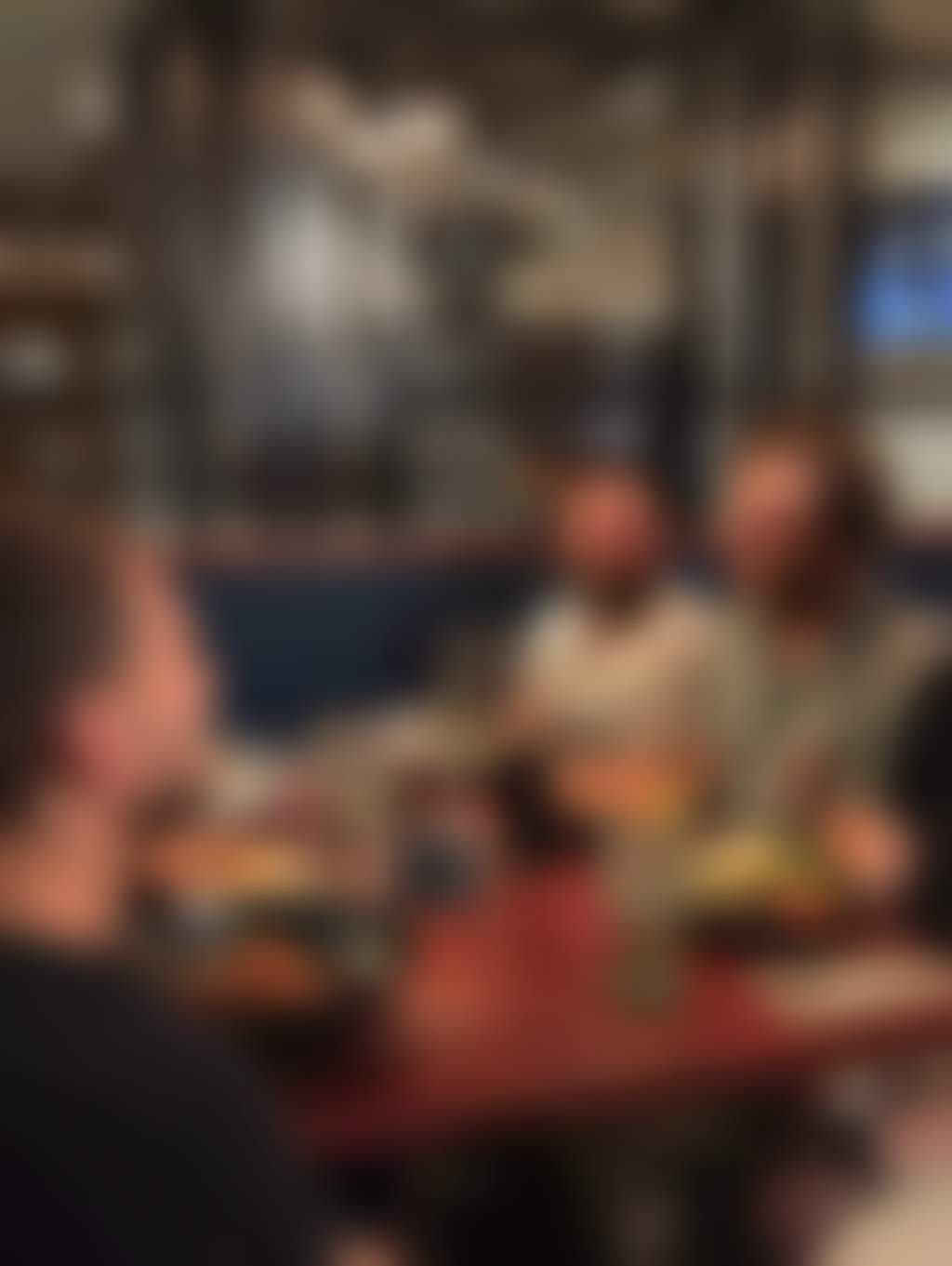 A group of friends enjoying food and drinks in a bistro setting