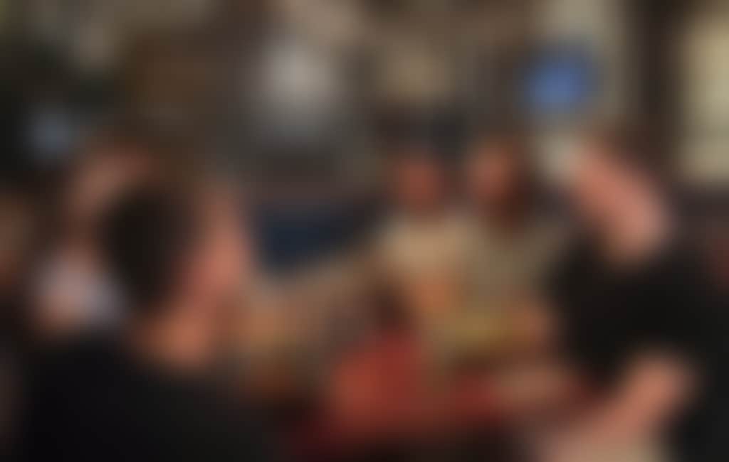 A group of friends enjoying food and drinks in a bistro setting