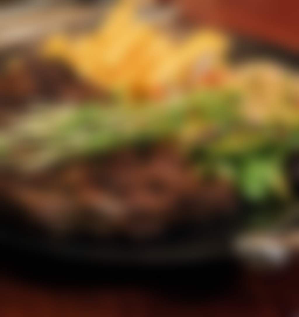 A big steak on a plate served with chips and salad