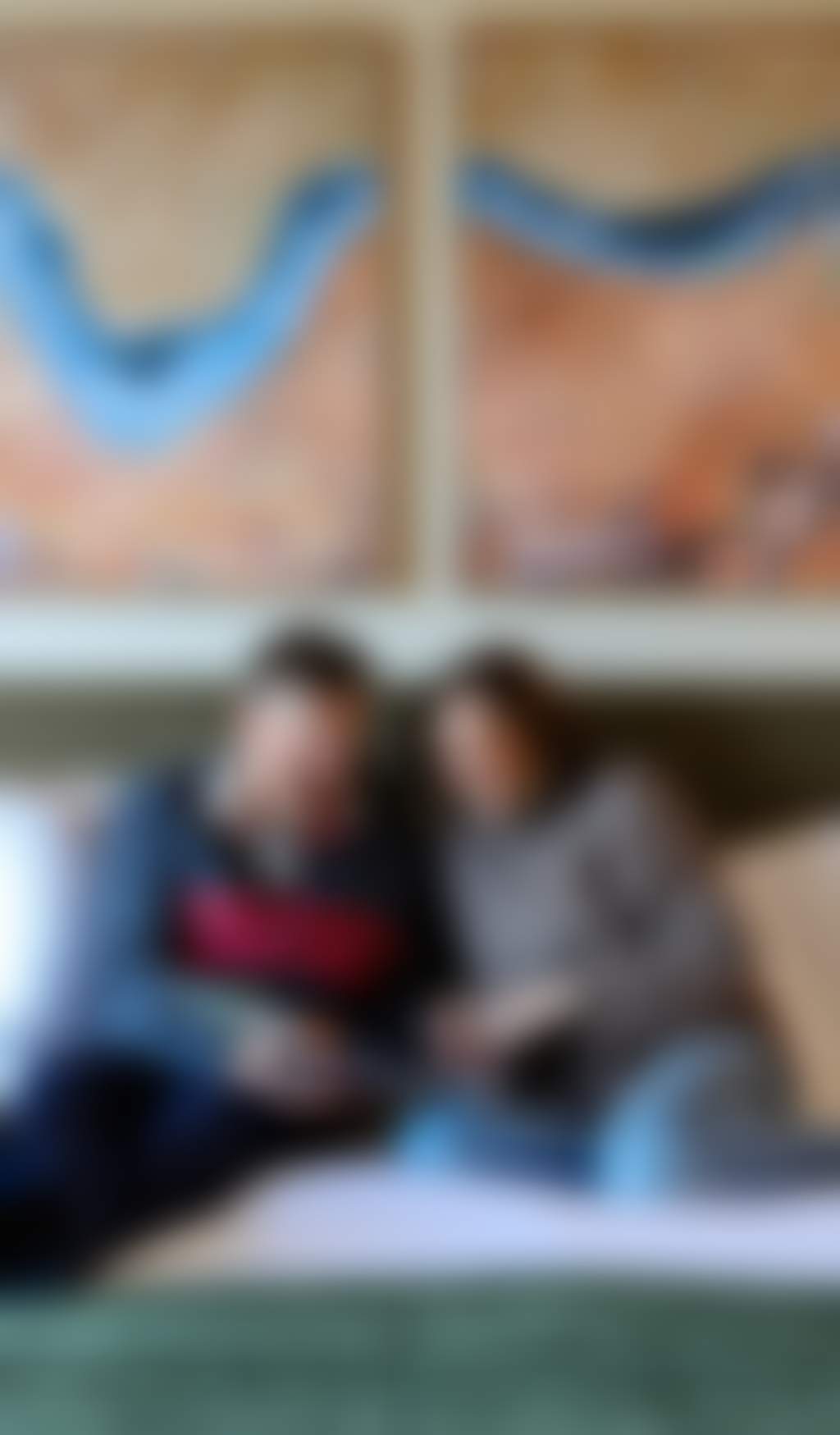 Resized mature couple reading on their bed in a modern hotel room