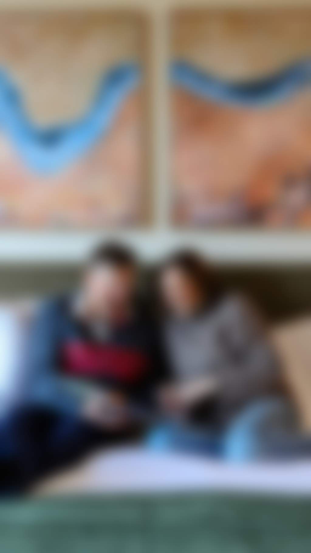 Resized mature couple reading on their bed in a modern hotel room