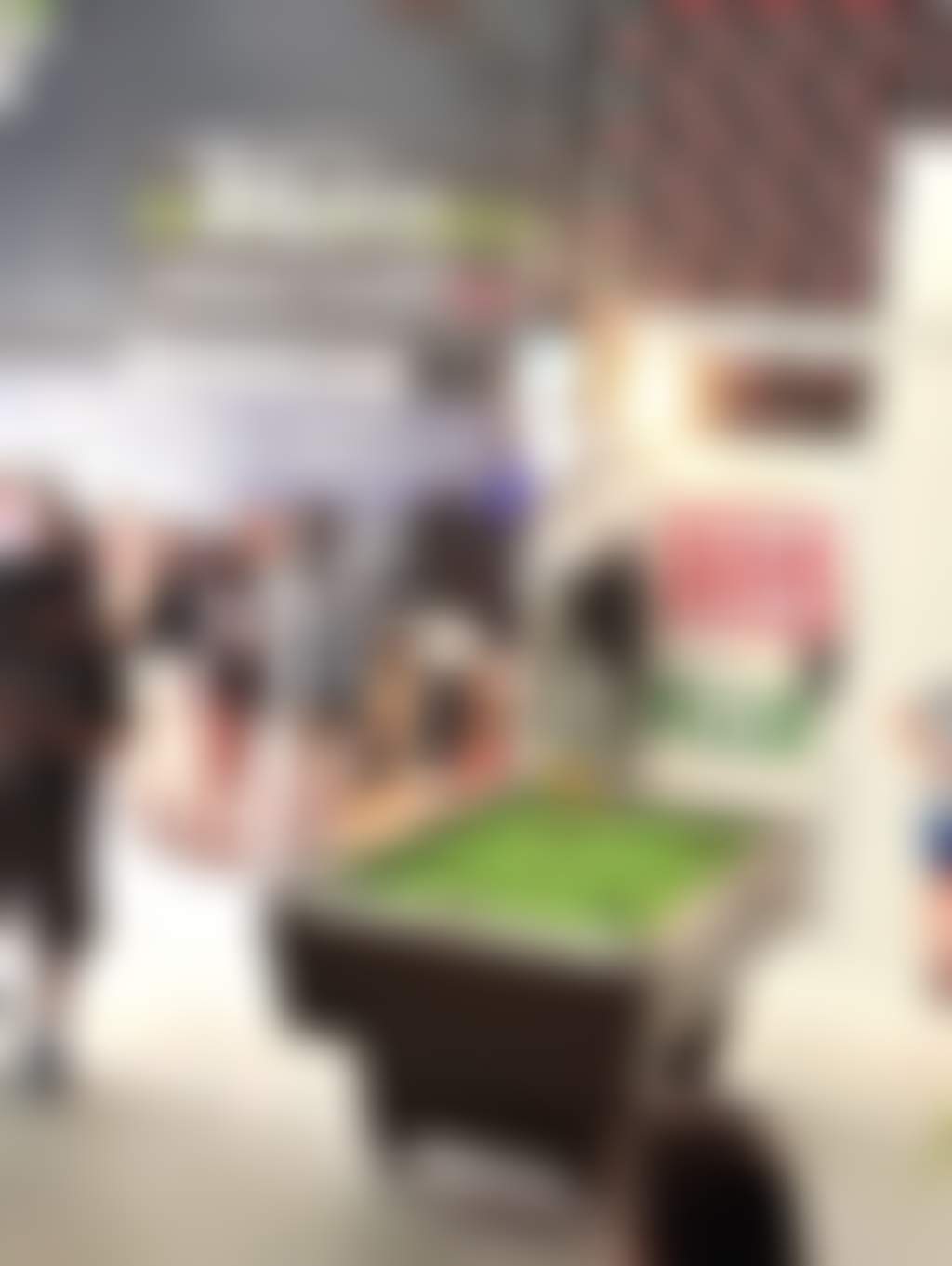 Interior of brewery, people playing pool and gathering at the bar